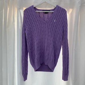 Stickad polo Ralph Lauren tröja - Knappt använd V-ringad lila tröja från polo Ralph Lauren. Lite mindre i storleken. Strl L men passar mer som M.
