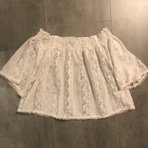 Vit offshoulder topp - En vit topp i spets, blir jättefint med en fin bh under då den är lite genomskinlig. Passar nog vilken storlek som helst då den är stretchig. Hör av dig vid frågor🥰