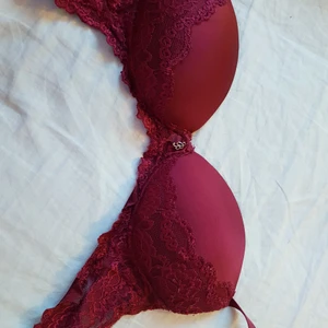 Röd spets-bh - Vinröd bh med vackra spetsmönster och även ett smyckesformat "B" i metall som en kan ta av om en vill. B-kupa. Ingen push up.