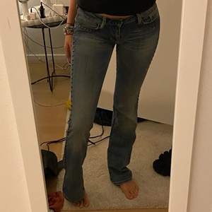 Low waisted bootcut jeans från Guess i storlek 27. De har sjukt snygga detaljer på sidan av byxorna✨ Använda fåtal gånger. Nyskick. Inga skavanker. Kan skicka fler bilder om så önskas. Frakt ingår ej i priset. Kan mötas upp i Stockholm ❤️‍🔥