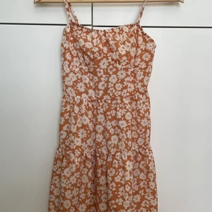 Sommar klänning  - En såååå vacker sommarklänning som är rosa/beige med blommor på. Spänn in bara axelband och en liten dragkedja på ryggen för att se baksidan bläddra till bild två,. För att se hur tyget ser ut bläddra till bild tre. Använd 6 ggr men fortfarande såå fin, Frakt 45kr!!