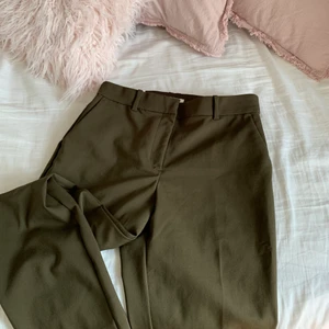 Bruna kostymbyxor - Kostymbyxor i rak modell med pressveck. Smickrande passform. Ser gröna ut på bilden men är rent bruna i verkligheten. Fel storlek för mig så aldrig använda