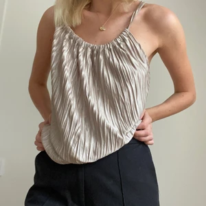 FESTTOPP - Guldig plisserat linne i mjukt material och rundad hals. Superfin och passar till allt