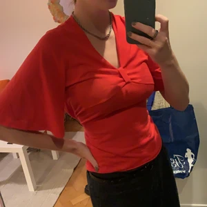 Röd topp - Röd topp som knyts där bak med två snören. Storlek M 