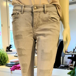 Jeans 7/8 dels läbgd - Jeans i Slim fit modell. Ljusgrå med sydda sömmar på benen och tufft uppvik med tryck nedtill. Stretching och low waist. 