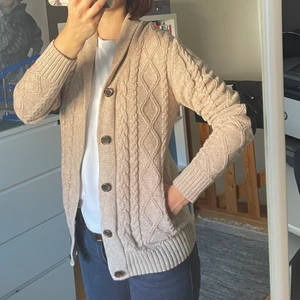 Beige cardigan i ullblandning s/m - En något längre varm och mjuk cardigan i bomull och ull. Har fina detaljer på armarna. Passar perfekt till hösten 🍂 längden 74 cm.