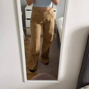 lågmidjade vida brun/beige jeans  - Säljer ett par as balla lågmidjade jeans. älskar dessa men har tyvärr blivit lite förstora för mig. använda enbart ett par gånger.  Ordinarie pris 800kr
