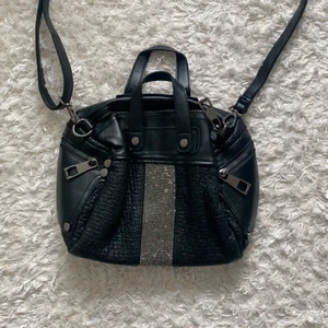 Svart läderväska  - Jättefin svart läderväska med kristallrand på men som tyvärr inte kommer till användning, använd endast en gång. Den kan andvändas som både handväska och axelväska. Säljer för 125+50 i frakt, startar budgivning ifall flera är intresserade.