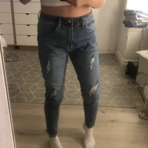 Blåa jeans - Blåa jeans med hål i, är för stora för mig som vanligt vis har s i jeans, mycket stretch, fint skick, köparen betalar frakten
