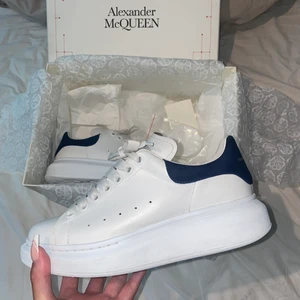 Alexander McQueen - Använda Alexander McQueen i vit läder och mörkblå mocka. Köpta på Illum i Köpenhamn. Väldigt bra skick (skriv för fler bilder). Ny pris 2950 DDK motsvarar 4063 SEK och säljs för 2500kr, köparen står för frakt. 