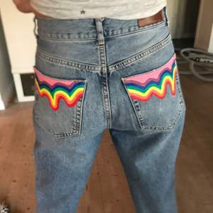 Ett par Never denim jeans i storlek M som är köpta second hand!! Jag har målat en droppeffekt på de två bakfickorna i regnbågens färger 🌈. Jeansen är i bra skick och i en urtvättad blå färg. Jeansen har knapp gylf. Färgen är textilfärg som är fixerad vilket gör att man kan tvätta jeansen 😁💗