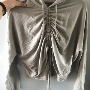 Tröja från bikbok med luva - Aldrig använd tröja köpt på bikbok. Man kan ändra längden där fram på tröjan med hjälp av snörena. 