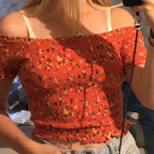 Topp - En röd topp med blommor på i storlek xs jag är en S och den är väldigt stretching, kan räkna in frakten i priset 