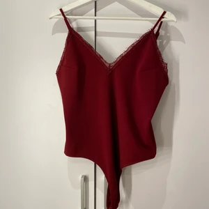 Vinröd bodysuit med spets - Jätte fin vinröd spets bodysuit med string så kanten inte syns! Köpt från bikbok och är aldrig använd. Skulle säga att färgen är mer lik i dom första bilderna än i den sista alltså en slags vinröd färg. Säljer pågrund av att den inte kommer till användning samt är lite för stor för mig. I storlek L men passar även M. Skriv för intresse samt om ni har frågor eller vill ha mer bilder på hur tröjan sitter osv❤️ pris kan diskuteras!