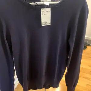 Helt ny marinblå tröja med prislappen kvar i storleken Xs.