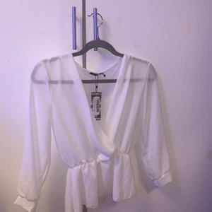 Vit blus stl S - En oanvänd vit blus med prislappen på, som inte har kommit till användning. 
