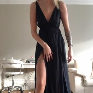 Klänning - Skit fin svart klännning passar perfekt till bal eller en sommarkväll, den har två slittqr och en inbyggd body.