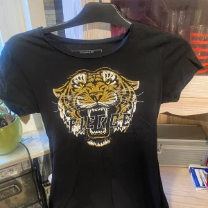 Svart t-shirt med tryck - En vart t-shirt med ett tryck på, vet inte riktigt vart den kommer ifrån men märket är primark. Storlek 36