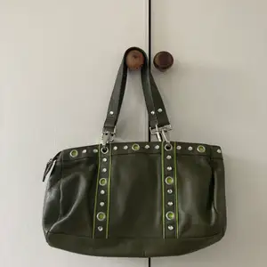 cool olivgrön väska med ljusgröna detaljer! inköpt second hand, men ej min stil längre tyvärr. bra skick, alla dragkedjor är hela osv! mått:32x20x7. hör av dig om det är något mer!