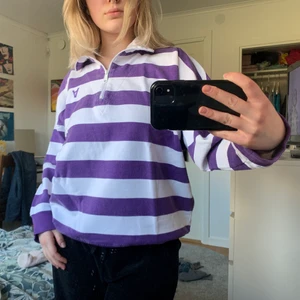 Vit/lila tröja stl.M - Denna balla tröjan från Carlings är en favorit hos mig, jag menar hur cool är den inte?!😍 Den sitter väldigt fint på kroppen och går att göra polo men går även att använda med krage. Den har en dragkedja som fingerar utan några problem! Köpte den på Carlings men det står Avrand Jeans på taggen. Skicket är super och materialet är superhärligt! 🥰