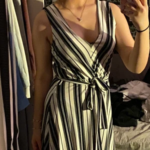 En randig klänning med snöre  - Klänningen är använd 1 gång på en avslutning, går att ha med både snöre och utan, väldigt luftig och skön att ha på sommaren då den kan svalka 