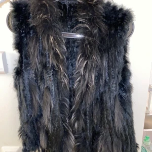 Svart pälsväst  - Äkta päls, one size , knäpps med knappar. Köpt i butik i Gamla Stan