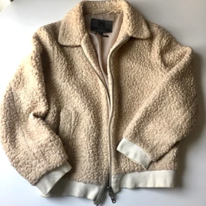 Brixtol Teddyjacka bomber Eve  - Cremefärgat och grov tovad ulljacka (40%) från Brixtol i Teddystyle med Bomberjacka form. Behöver en liten tvätt längs kanterna snart men annars i fint skick. Limiterad upplaga med vita kanter! Slutsåld. Storlek XS som oversize. Passar S mycket bra. Nypris 1.800kr og köpt begagnat för 1.190kr.