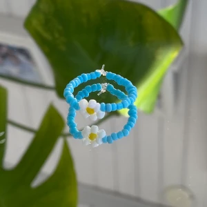Egentillverkad Ring - Blå ring med blomma, egentillverkad! 💙                   Passar S-M                                                                         Säljer för 15kr + 12kr i frakt. Fraktpriset är det samma oavsett antalet ringar man köper ✨