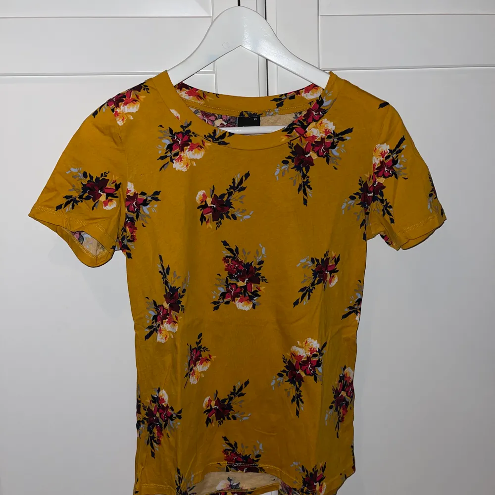 Säljer denna T-shirt jag köpte från ginatricot för några år sedan använt den 1 gång inte mer än det, den är jättefin och otroligt skön är senapsgul med fina blommor på, passar perfekt till sommaren. T-shirts.
