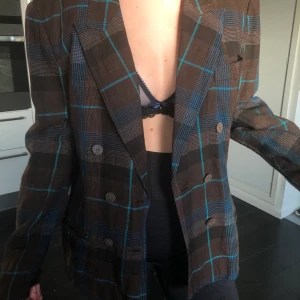 Brun kavaj - Brun kavaj med blåa detaljer. Köpte på second hand. Väldigt snygg!!!! Skulle gissa att storleken är 38 men sitter snyggt oversized på mig som är strlk 34-36 