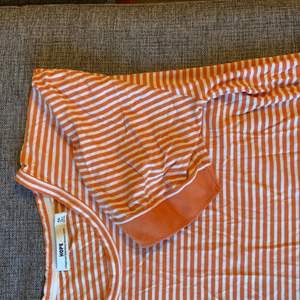Orangerandig tröja/topp. Står strl. 50 men skulle säga en M för män och L för kvinnor. 