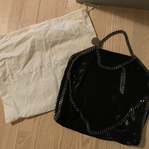 Stella McCartney handbag and shoulder chain - Stella McCartney Bag Svart Falabella kedjetrimmad tote väska från STELLA MCCARTNEY med kedjelänk, magnetfäste, logotyp charm, invändig ficka med dragkedja och foder med logotryck. 