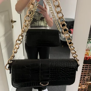 Axelväska  - Jättefin axelväska från Nelly med snakeskin och gulddetaljer. Väldigt lite använd så den är så gott som ny. Ett dragkedjefack inuti. Väldigt smidig väska som passar perfekt som axelväska.  