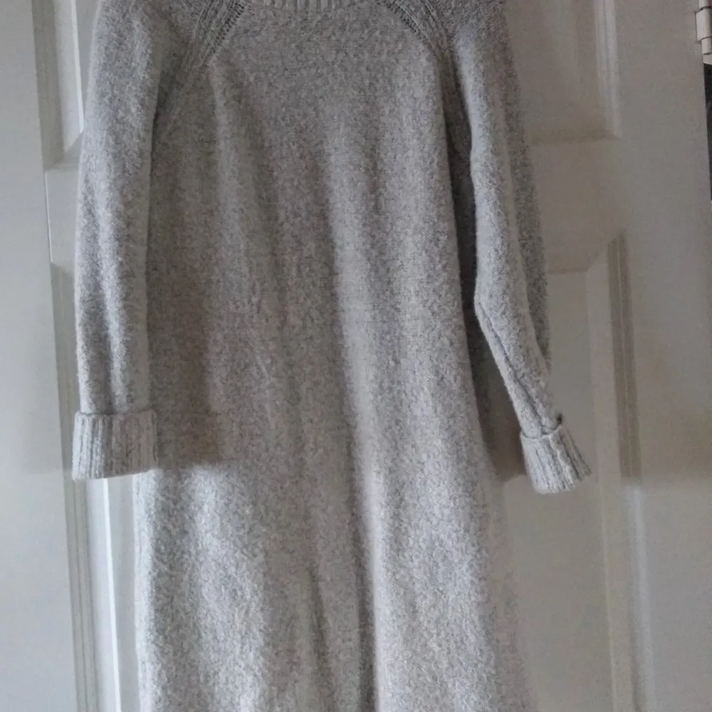 En stickad poloklänning från H&M. Den är ljusgrå och liten längre än knäna på mig (168 cm). . Klänningar.
