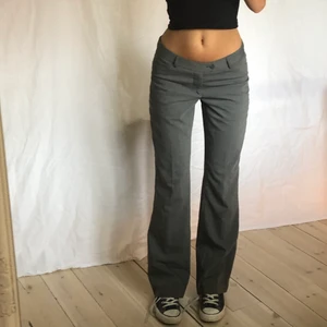 Lågmidjade grå kostymbyxor - Sååå snygga lågmidjade kostymbyxor, är 174 och innerbenslängden på byxan är ca 83 cm och midjemåttet ca 77 cm (en liten defekt där det redan lossnat lite i sömmen nere vid foten men kan lätt sys till/sprättas)🤎🤎 ❌ LÄGG ENDAST BUD OM DU KAN OCH VILL KÖPA!!❌ 