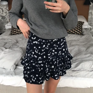 Volangkjol från H&M - Säljer denna volangkjol från H&M. Storlek 32 men passar mig som har XS. Den är mörkblå med lite vita fläckar. Spårbar frakt tillkommer på 51kr