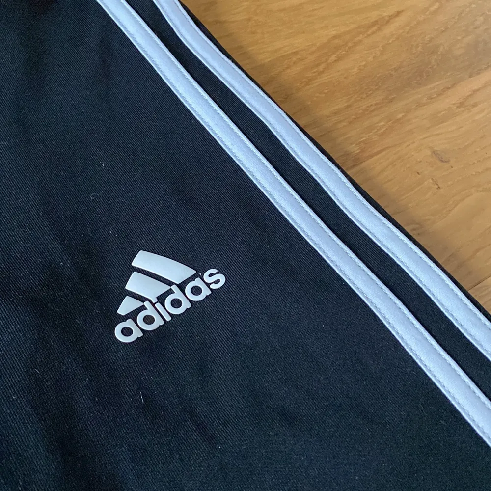 Sköna svarta Adidas  träningsbyxor med en vit rand på sidan. Även väldigt sköna för att ha som inne mys byxor.. Jeans & Byxor.