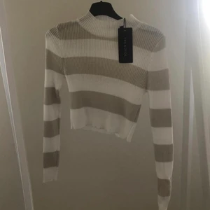 Vit/brun randig croptop strl S - Aldrig använt denna croptop så lappen sitter fortfarande kvar, bra skick! Köpt på NaKd men kommer från märket trendyol.