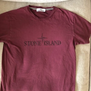 Stone Island T-Shirt - Stone Island Tröja troligen från 2017s sommar/vår kollektion. Färgen är vinröd och storlek L. Den är lite urtvättad o sprickor har uppkommit på loggan på bröstet men som bara blir snyggt då det finns så många nyare så ser denna mer klassisk ut.