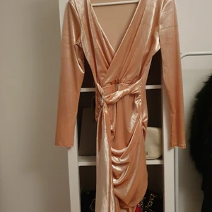 Gammelrosa klänning i sammet storlek s  - Klänning i gammelrosa sammet, med ett band runt som går att knyta och justera. Aldrig använd, men prislappen är borttagen. V-ringad och har bra passform. Köpt från BikBok 