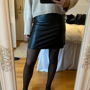 Läderkjol - Svart ”läder” kjol från Nelly. Helt oanvänd, prislappen finns kvar! Storlek XS men funkar bra för S också.