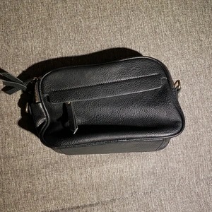 Väska - Band medföljer inte. Väldigt rymlig för sin storlek