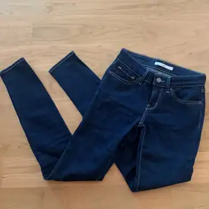 Tajta jeans från Levi’s. Modell 711 Skinny. W24. L32. Mörkblå tvätt med ljusa sömmar. Stretchiga. Inte använda mer än en eller två gånger pga för små, därav fina i skick. Köpare står för frakt 