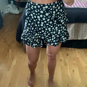 Svart blommig byxkjol  - En svart byxkjol med vita blommor. Volanger fram och på sidan men inte där bak. Dragkedja där bak. Storlek M. Aldrig använd pga för liten. Från Zara. Köpare står för frakt. 