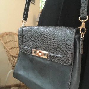 Väska med axelband  - Jättesöt väska i orm-imitation. Axelremsband som går att justera. Eller ta av helt och hållet och använda väskan som clutch. Frakt tillkommer. 