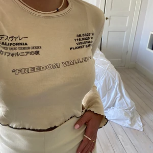 Crop top - Crop top från Urban outfitters med asballt tryck i beige/offwhite