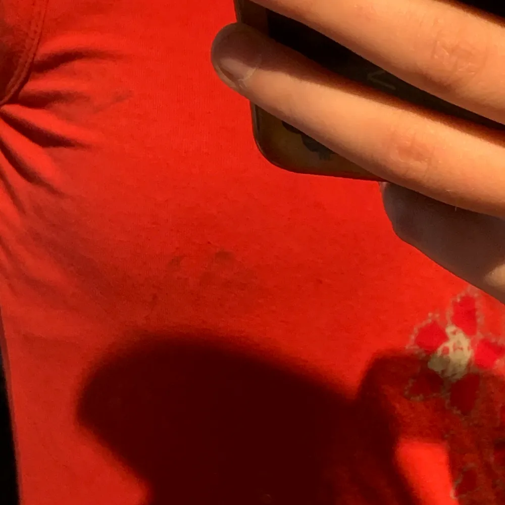 Väldigt fint rött linne med söta detaljer av blommor. Jätte fin passform. Tyvärr har den en liten fläck på vänstra bröstet som ej går bort men fläcken är knappt synlig om man inte står o stirrar.. Toppar.