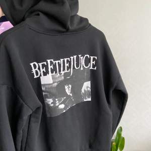 Min älskade beetlejuice hoodie behöver en ny bärare 🥲 bra att ha i kyliga sommarkvällar. as cool tryck med Lydia (winona ryder) på ryggen. den är i super bra skick, sitter perfekt oversize på xs/s. frakt tillkommer 🤍