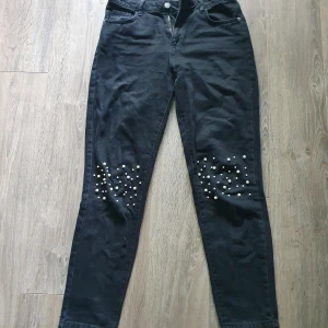 Svarta jeans med pärlor - Nakd - Svarta jeans med pärlor på knäna från Nakd i stl 38, skulle säga att dom passar som 36 också. Är mom-fit modell. Mer bilder vid intresse. Pris exklusive frakt.