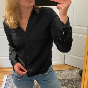 Svart skjorta - Svart skjorta med silkesliknande material! Superfin som den är, men även över en topp. Använd ca 2 gånger💕